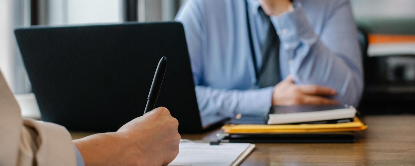 Crop anonymous female filling questionnaire when applying for job sitting in employer office