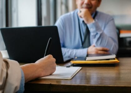 Crop anonymous female filling questionnaire when applying for job sitting in employer office