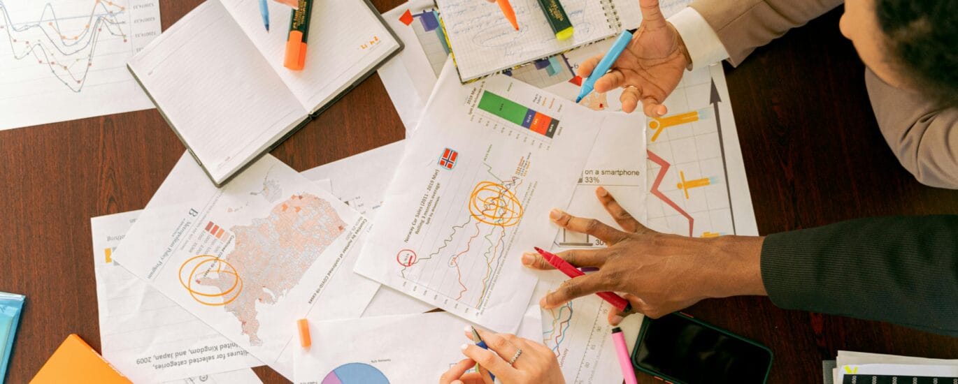 Business professionals collaborating over charts and data in a conference room.