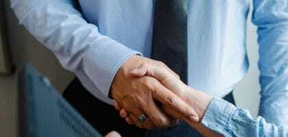 Male and female business partners in formal clothes shaking hands after successful deal.
